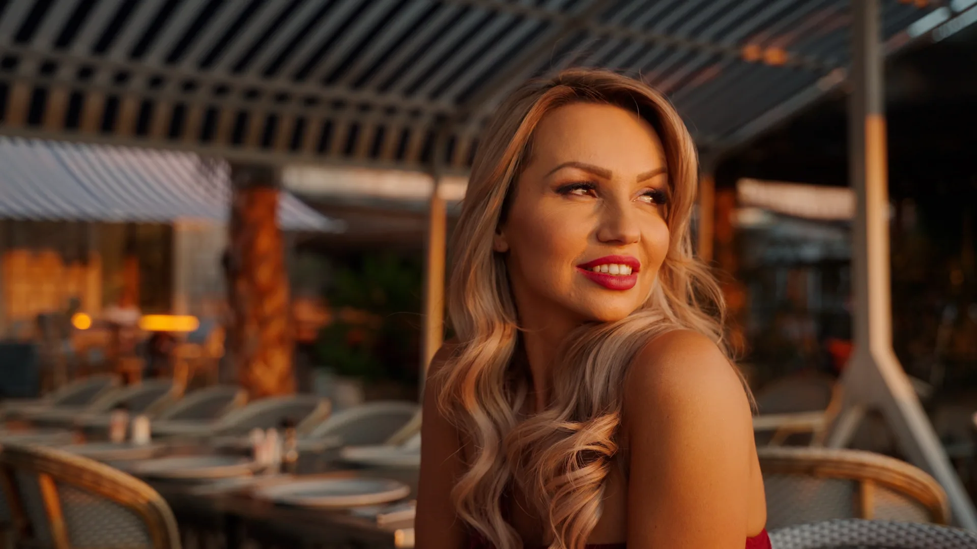 Agnieszka w promieniach zachodzącego słońca na tle nadmorskiej restauracji