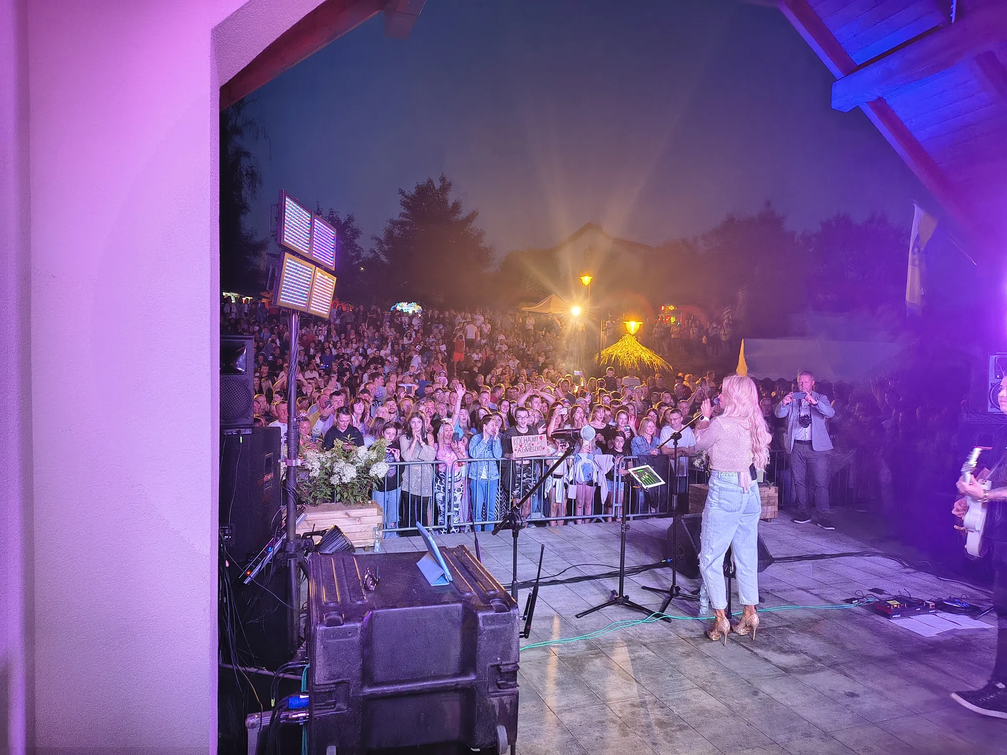 Agnieszka śpiewa do tłumu fanów; w pierwszym rzędzie widać transparent Kochamy Cię Agnieszko